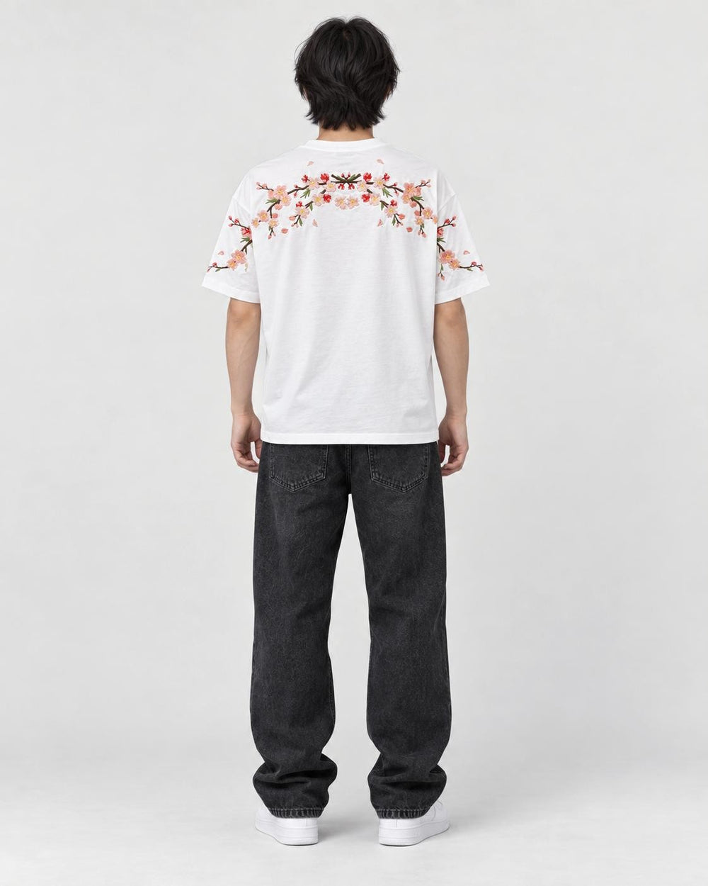 Model wearing the white plum blossom T-shirt, back view of the embroidery