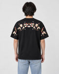 Model wearing the black plum blossom T-shirt, back view of the embroidered garland