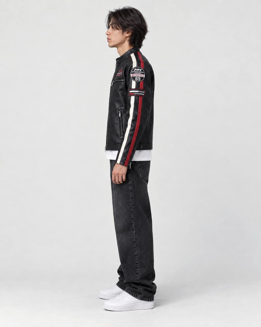 Model wearing the black racing patch moto jacket, side view of the sleeve stripes