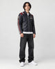Model wearing the navy racing stripe moto jacket, three-quarter view