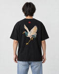 Model wearing the black crane embroidered T-shirt with light-wash jeans, back view