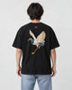 Model wearing the black crane embroidered T-shirt with light-wash jeans, back view
