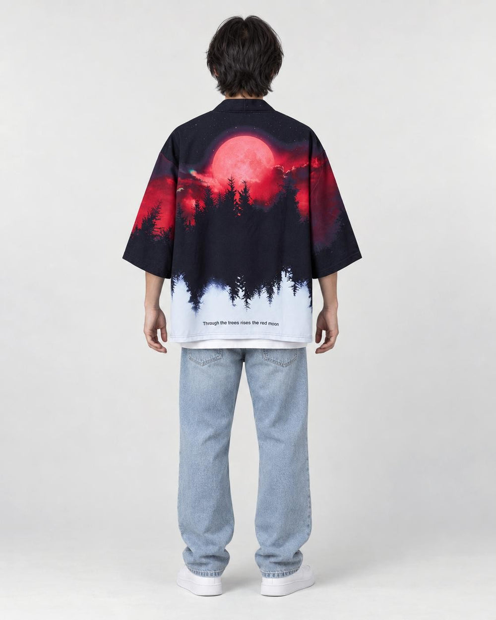 Full-length back view of a man in the haori with a red moon over a black pine forest fading to white, with light jeans