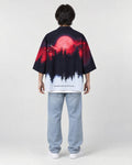 Full-length back view of a man in the haori with a red moon over a black pine forest fading to white, with light jeans