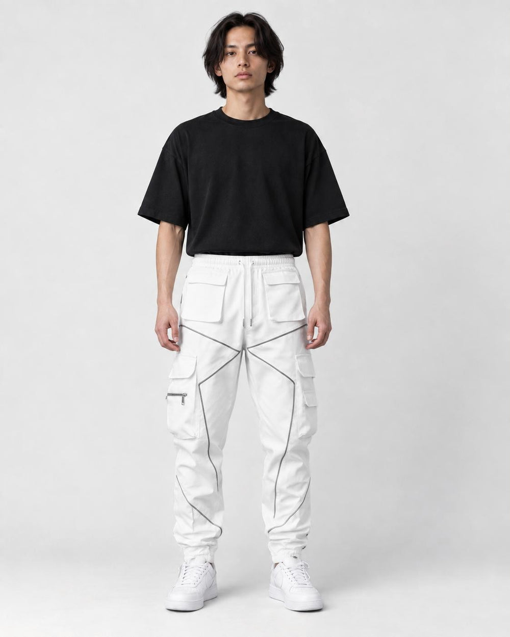 Model wearing white cargo joggers with gray-silver tape lines and a black tee, front view