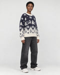 Model wearing the navy reindeer Christmas sweater, three-quarter view