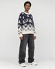 Model wearing the navy reindeer Christmas sweater, three-quarter view