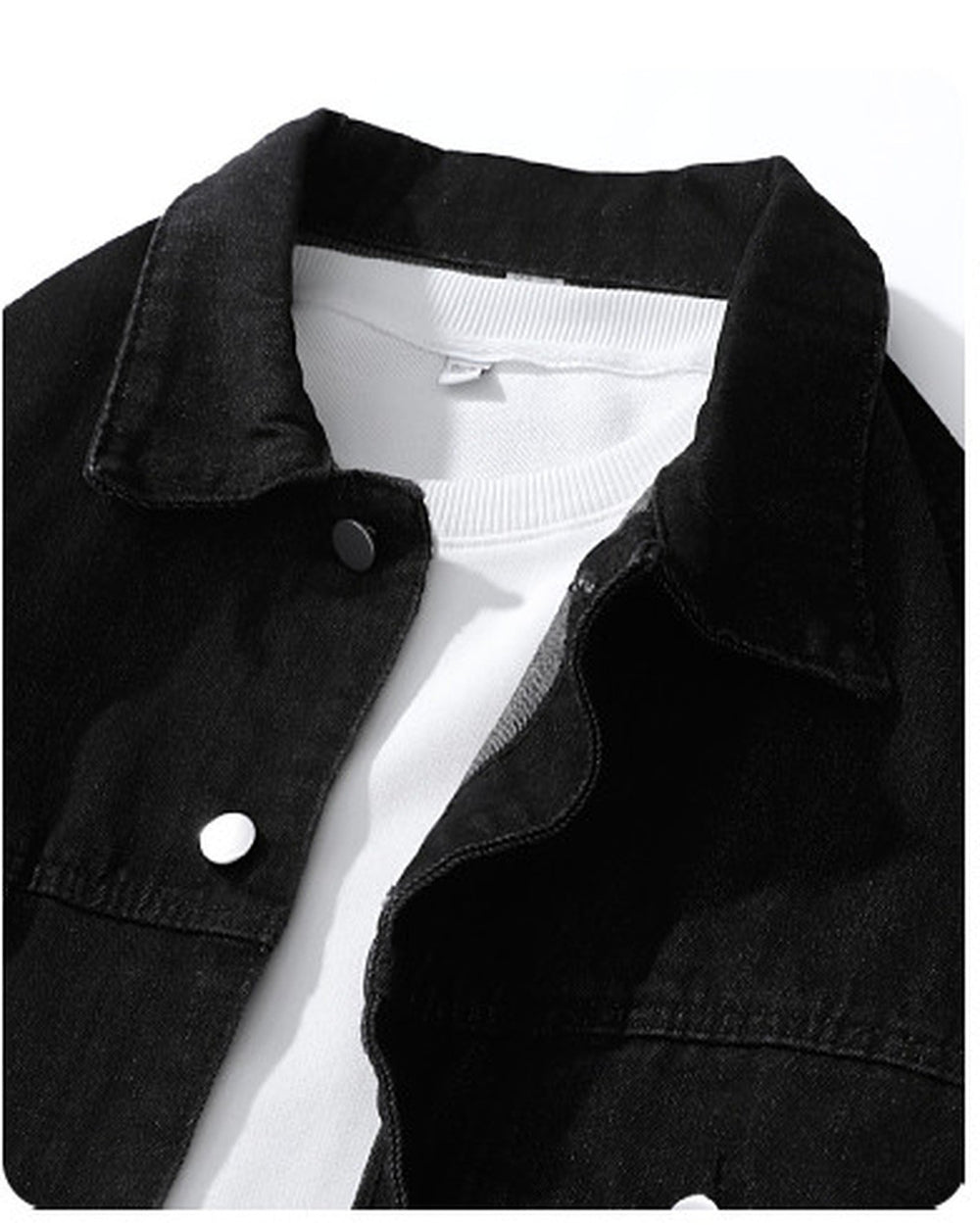 Close-up of the black denim collar, chest pocket edge and metal buttons
