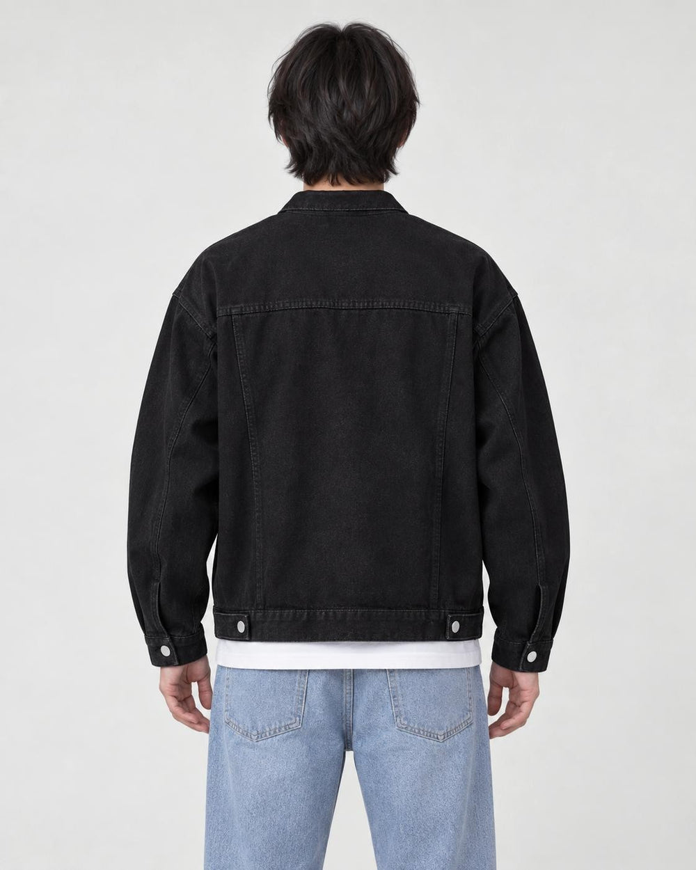 Model wearing the black denim trucker jacket, back view