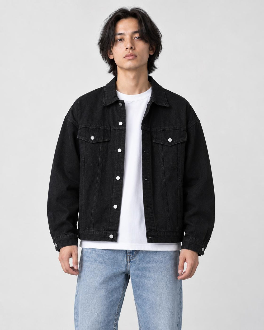 Model wearing the black denim trucker jacket open over a white tee, front view