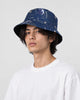 Model wearing the navy astronaut and star chart bucket hat with a white tee, three-quarter view