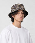 Model wearing the brown great wave print bucket hat with a white tee, three-quarter view