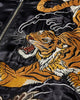 Close view of the orange and gold tiger embroidery with white whiskers beside the zip on glossy black fabric