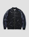 Plain reverse side of the jacket in glossy black with navy raglan sleeves and a silver zip