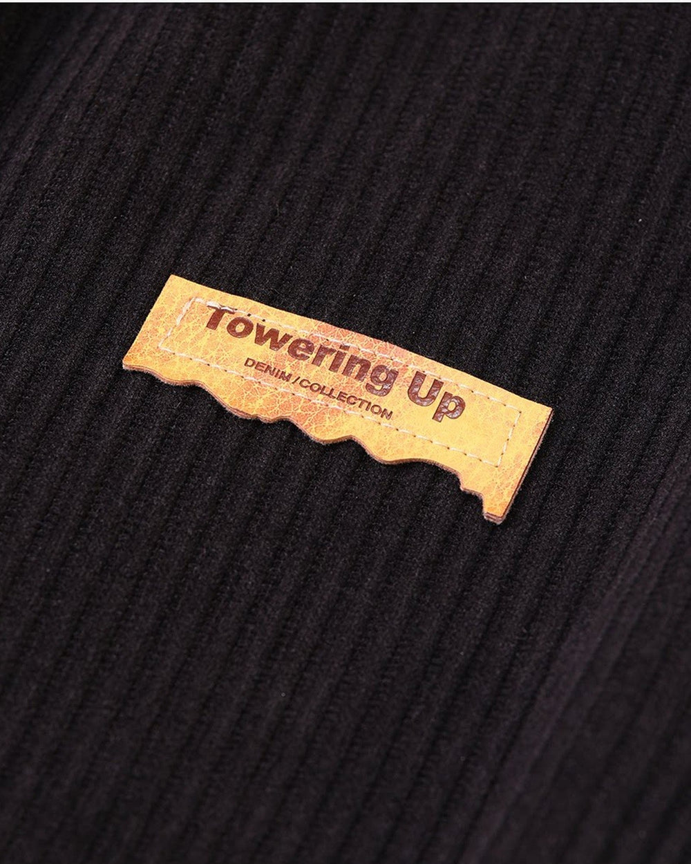 Close-up of the small tan tag sewn on the ribbed corduroy at the left hip