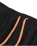 Close-up of the elastic waistband and the tan drawcord on the black pants