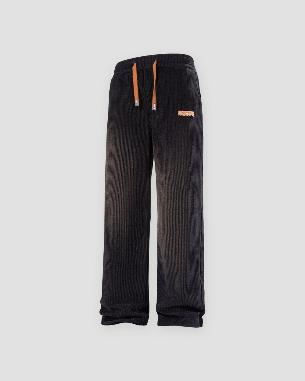 Black ribbed corduroy wide-leg pants with a tan drawcord and a tan tag at the left hip