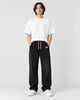 Model wearing black ribbed corduroy wide-leg pants with a white tee and white sneakers, front view