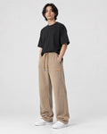 Model wearing khaki ribbed corduroy wide-leg pants with a black tee and white sneakers, three-quarter view