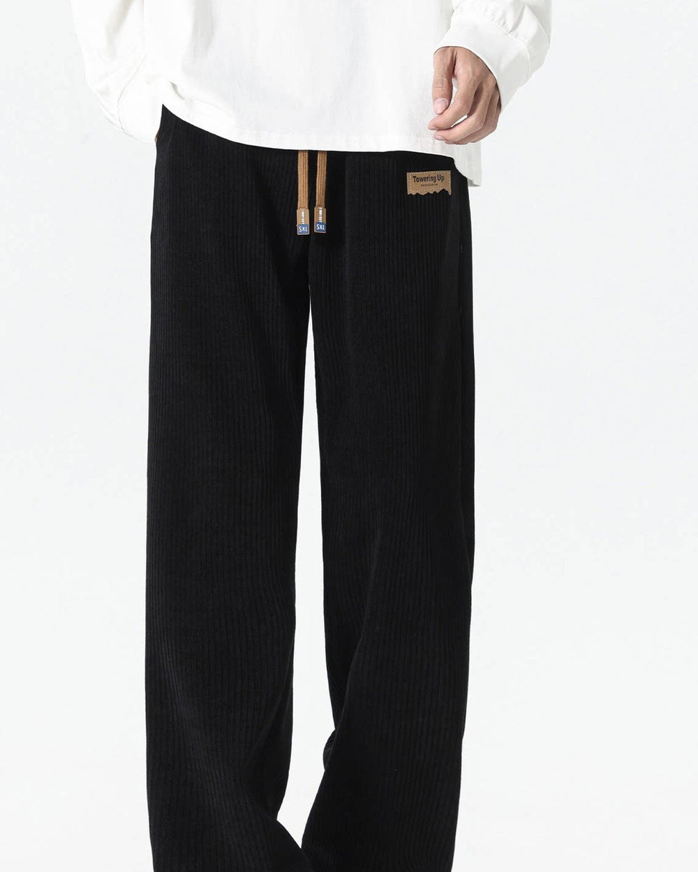 Black ribbed corduroy wide-leg pants with a tan drawcord, worn with a white sweatshirt