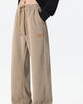 Khaki ribbed corduroy wide-leg pants with a tan drawcord and a tag at the hip