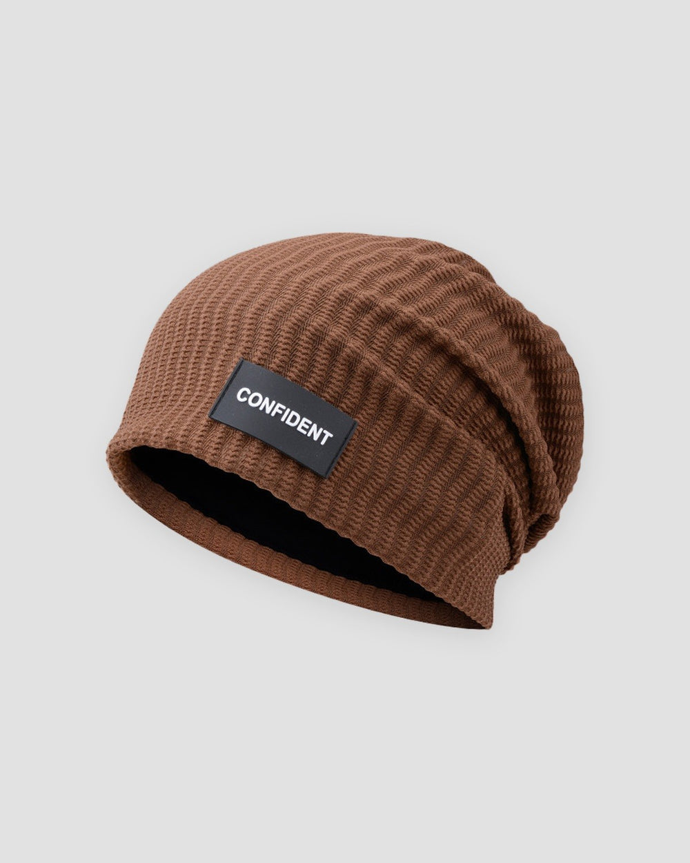 Brown ribbed slouchy beanie with a small black label reading CONFIDENT