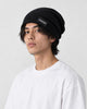 Man wearing the black ribbed slouchy beanie with a CONFIDENT label, three-quarter view