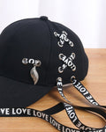 Close-up of the LOVE ribbon lacing and the silver leaf pendant on the black cap