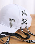 Close-up of the LOVE ribbon lacing and the silver leaf pendant on the white cap