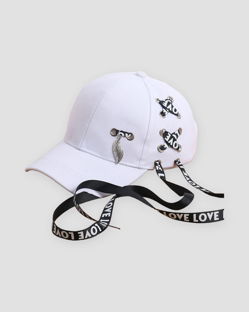 White baseball cap laced with LOVE ribbon and a silver leaf pendant, three-quarter view
