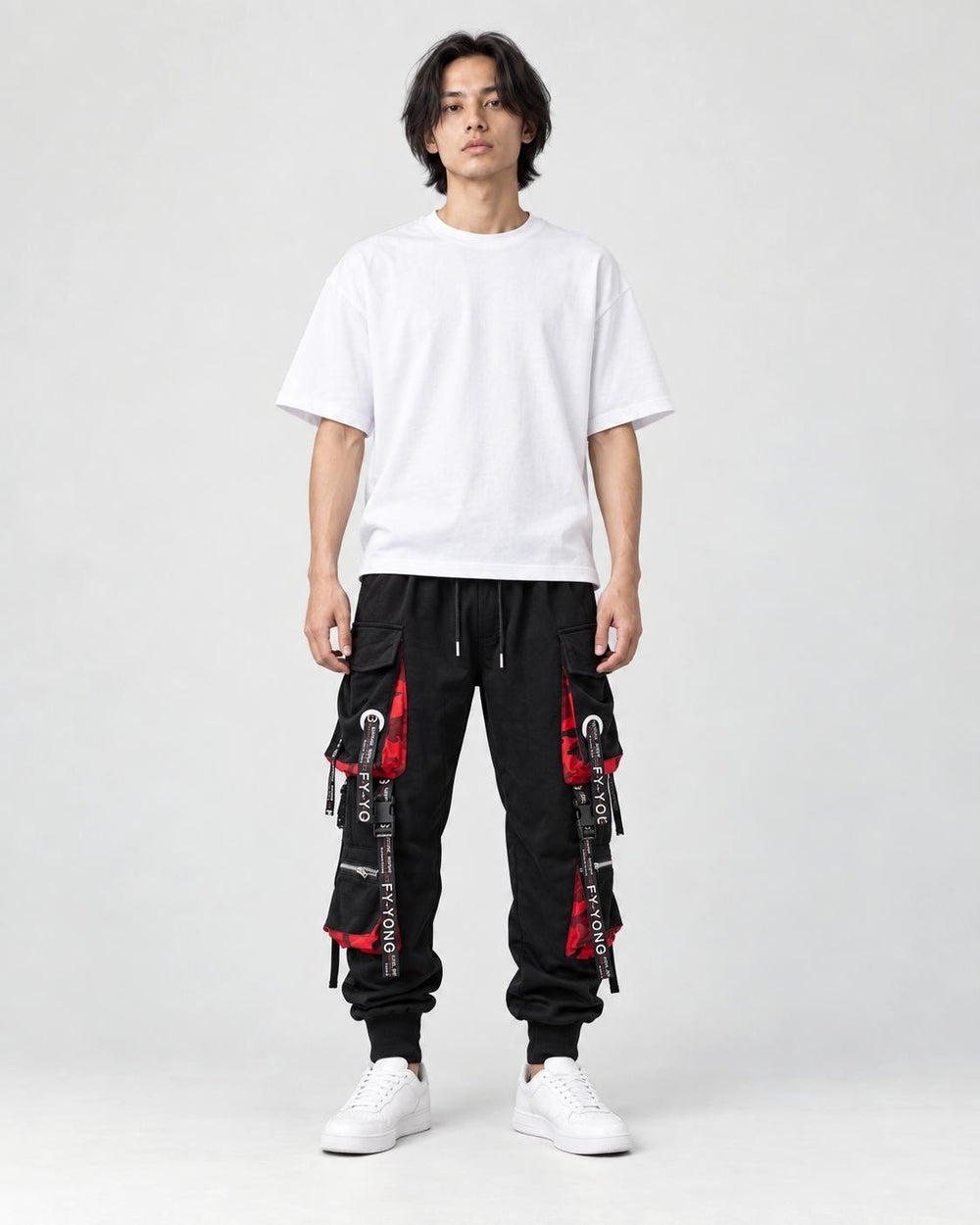 Model wearing the black ribbon strap cargo joggers with a white tee and off-white sneakers, front view