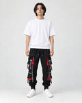 Model wearing the black ribbon strap cargo joggers with a white tee and off-white sneakers, front view