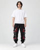 Model wearing the black ribbon strap cargo joggers with a white tee and off-white sneakers, front view