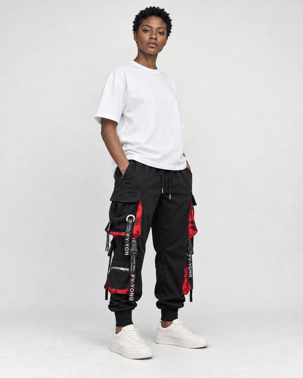 Model wearing the black ribbon strap cargo joggers with a white tee, three-quarter view