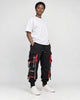 Model wearing the black ribbon strap cargo joggers with a white tee, three-quarter view