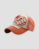 Orange distressed cap with a riveted fist patch outlined in red