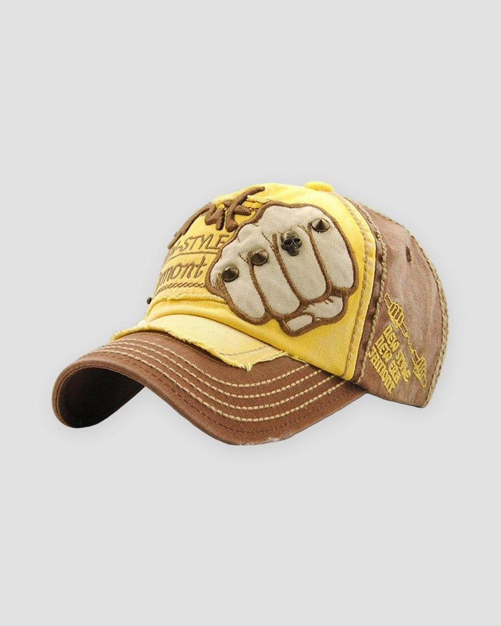 Yellow and brown distressed cap with a riveted fist patch