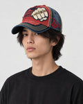 Model wearing the red and navy fist patch cap, turned three-quarter view