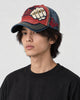 Model wearing the red and navy fist patch cap, turned three-quarter view