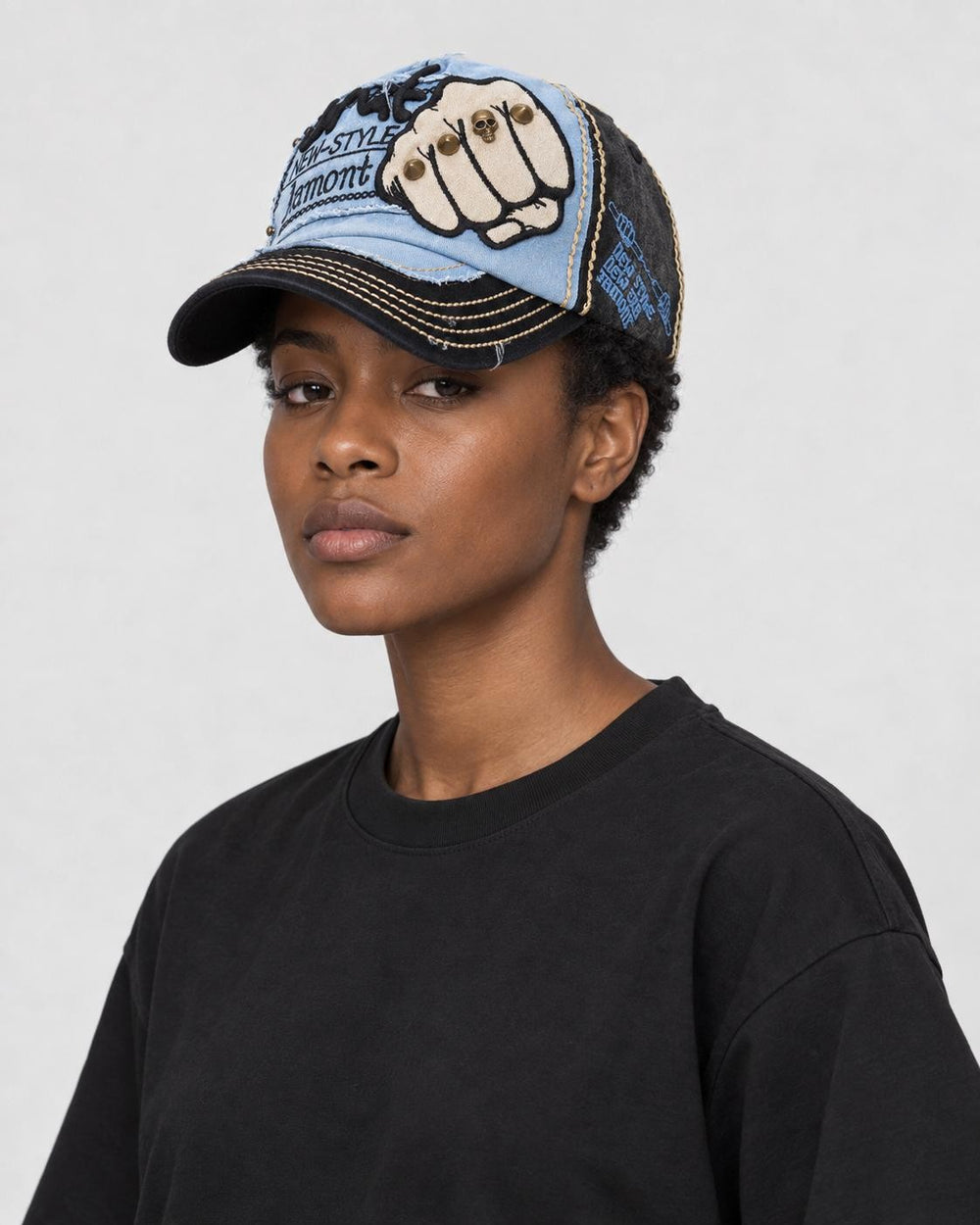 Model wearing the light blue and black fist patch cap, three-quarter view