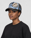 Model wearing the light blue and black fist patch cap, three-quarter view