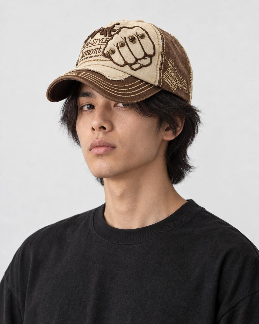 Model wearing the beige and brown fist patch cap, three-quarter view