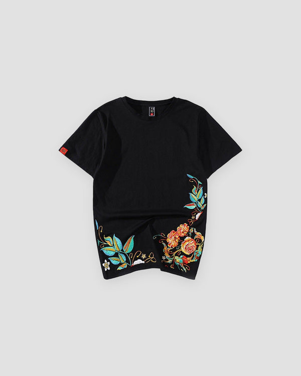 Black cotton tee with roses and teal leaves embroidered along the lower hem