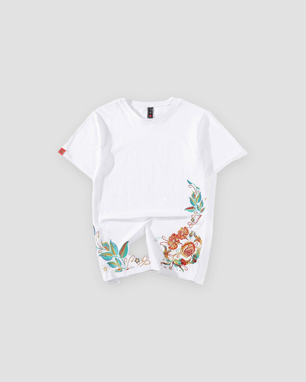White cotton tee with roses and teal leaves embroidered along the lower hem