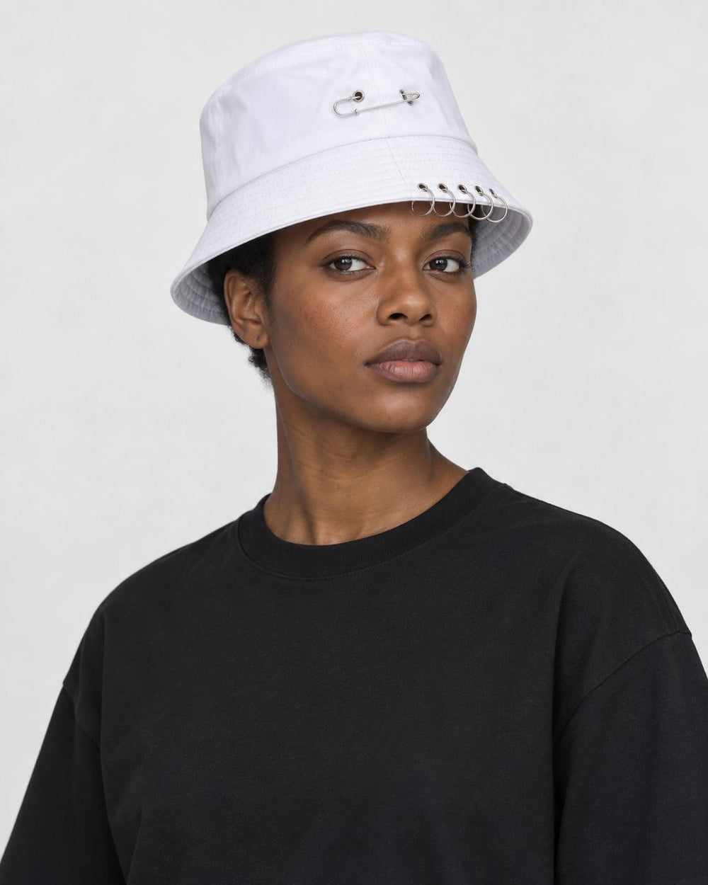 Model wearing the white safety pin bucket hat, three-quarter view