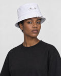 Model wearing the white safety pin bucket hat, three-quarter view