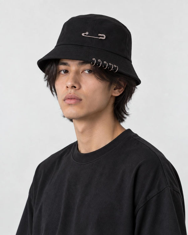 Model wearing the black safety pin bucket hat, three-quarter view