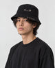 Model wearing the black safety pin bucket hat, three-quarter view