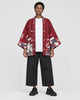 Model wearing the sakura print kimono jacket open, red side out, front view