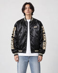 Model wearing the black bomber jacket with cream sleeve lettering over a white tee, front view